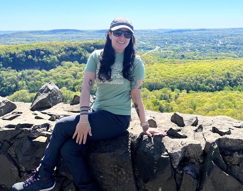 Carolina Herrera, Norwalk Hospital spinal fusion patient, sitting on a rock during a hike.