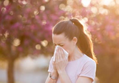 Woman with Allergies blows nose