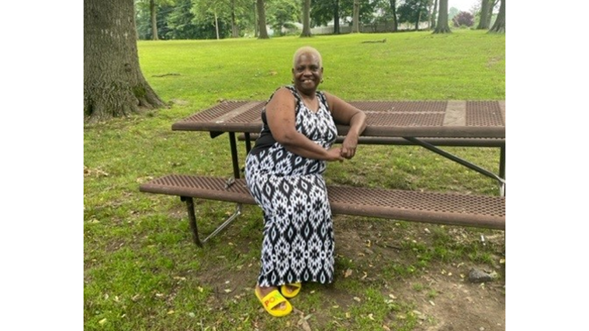 Barbara Brickhouse, 68, Beacon, New York. Barbara is a two-time cancer survivor. She is sitting on a bench outside in a park in the summer.