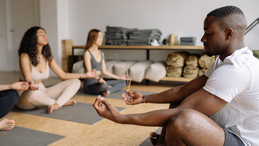 Three people meditating and doing yoga