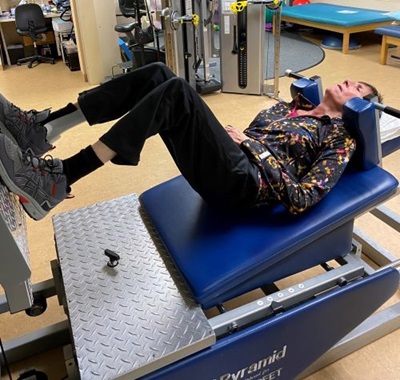 Sixty-three-old woman is exercising in a rehabilitation gym after she had a stroke four years ago. 