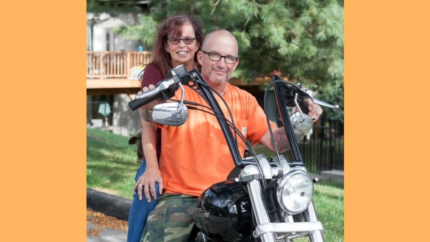 COVID-19 survivor Denise Marshall and her husband pose on their motorcycle. 
