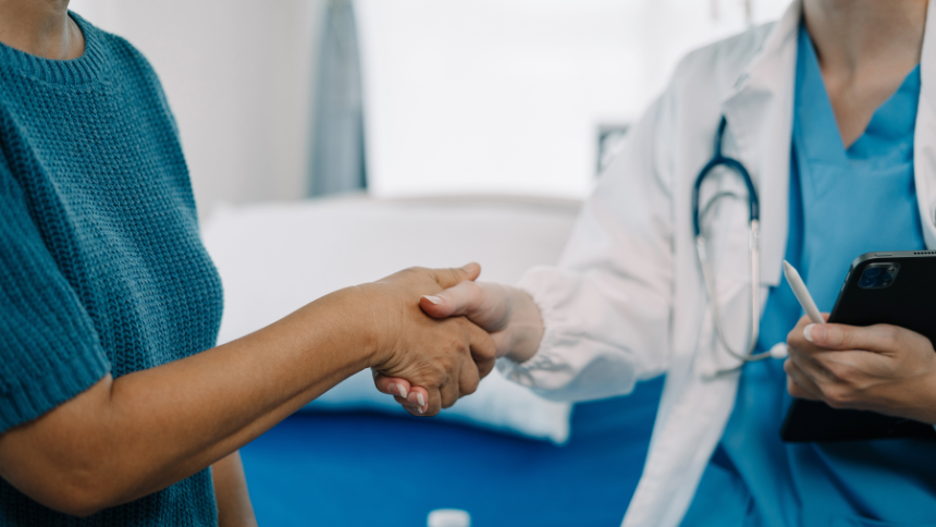 Female doctor shakes hands with patient to offer love, concern and encouragement.