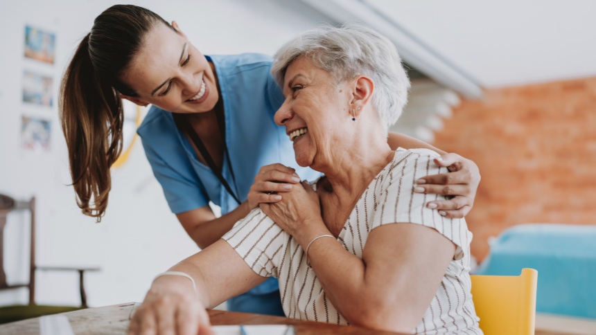 Home care healthcare professional hugging senior patient 