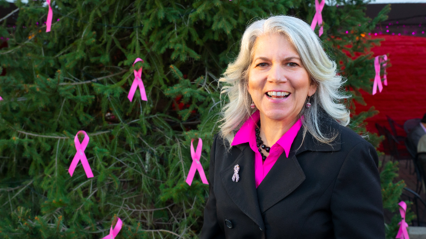 Dr. Lisa Curcio, a breast surgeon at Northern Dutchess Hospital, is standing outside a tree decorated with pink ribbons at the inaugural Light the Village Pink kickoff event in Rhinebeck, NY.