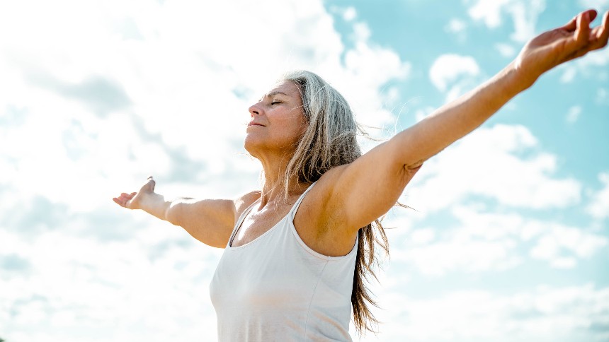 Woman arms outstretched on sky background