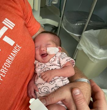 Smiling preemie is held by her dad