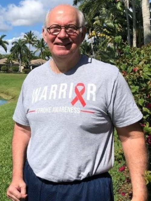 Mike Foster wearing a stroke survivor t-shirt outside on a golf course in the summer. 