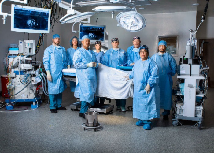 Surgeon, nurses and other staff surround an operating room table at Vassar Brothers Medical Center in 2022