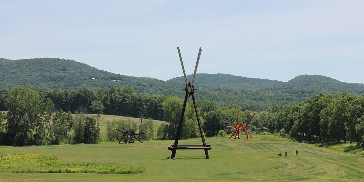 A gigantic piece of metal art in the middle of a field at the Storm King Art Center