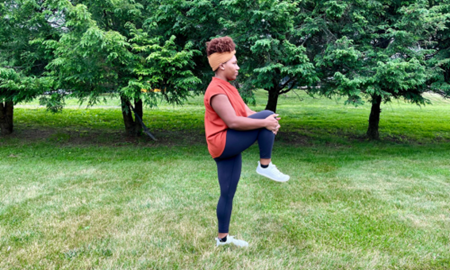 Woman doing a high knee stretch.