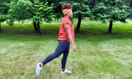 Woman doing a back leg swing stretch.