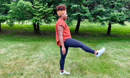 Woman doing a front leg swing stretch.