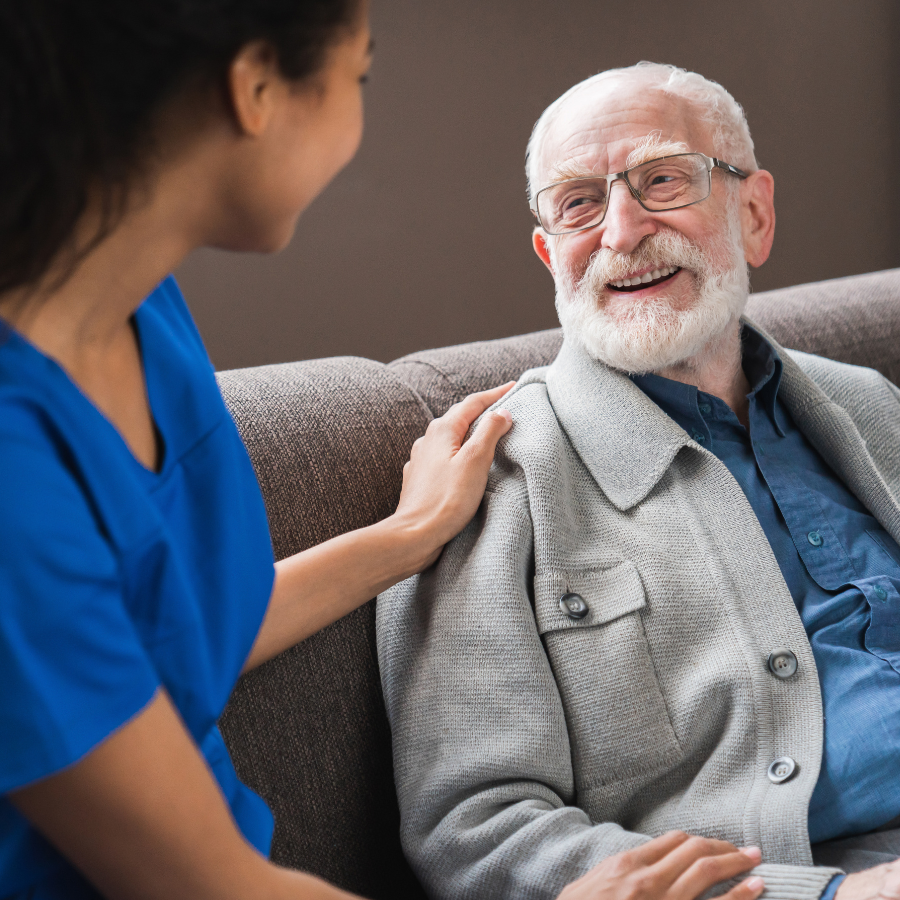 Caregiver talking chatting to happy senior man