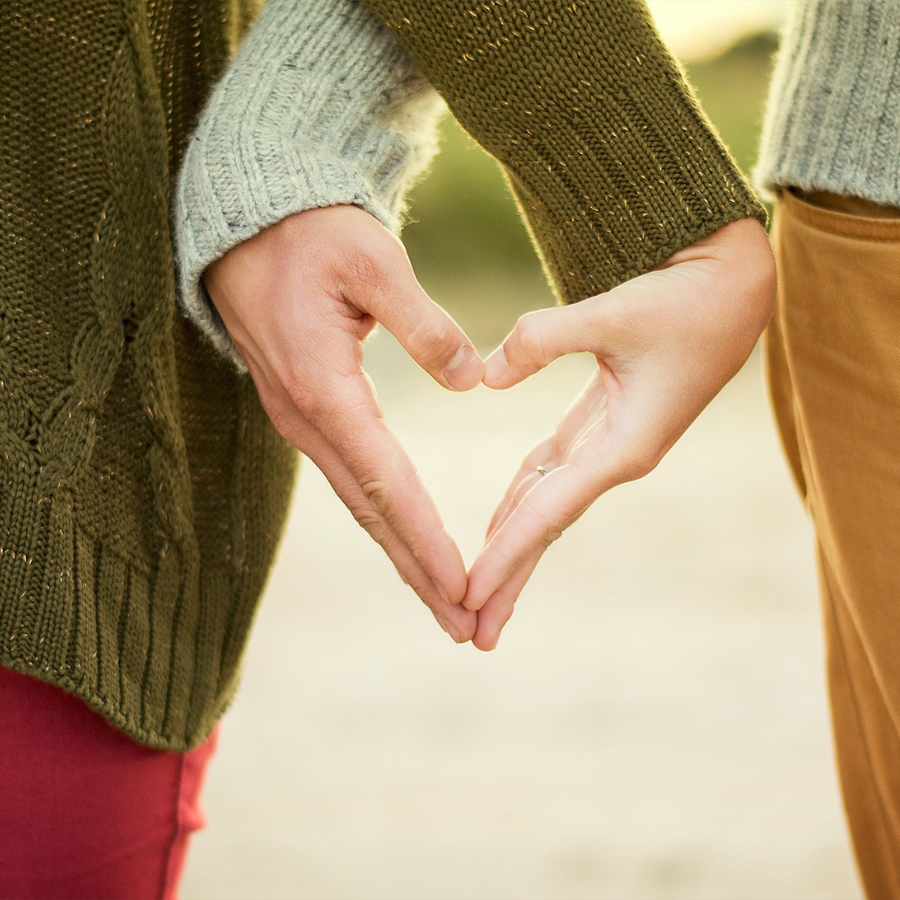 Couple forming heart shape with hands