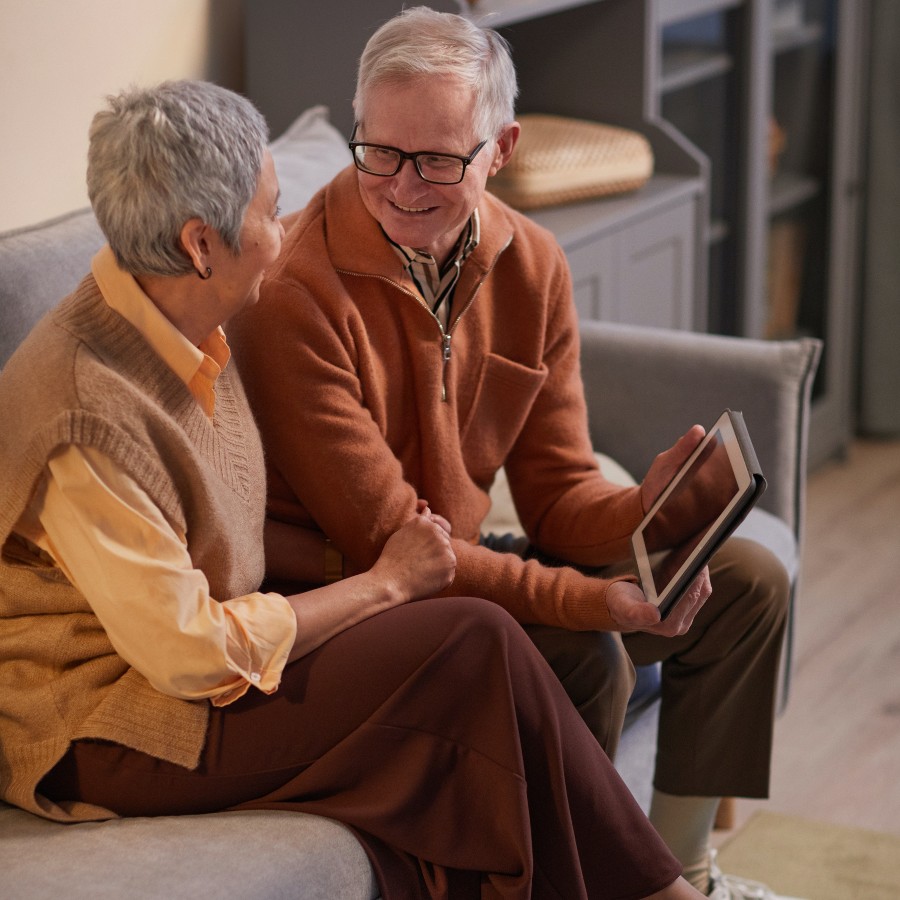 Couple smiling while looking at tablet