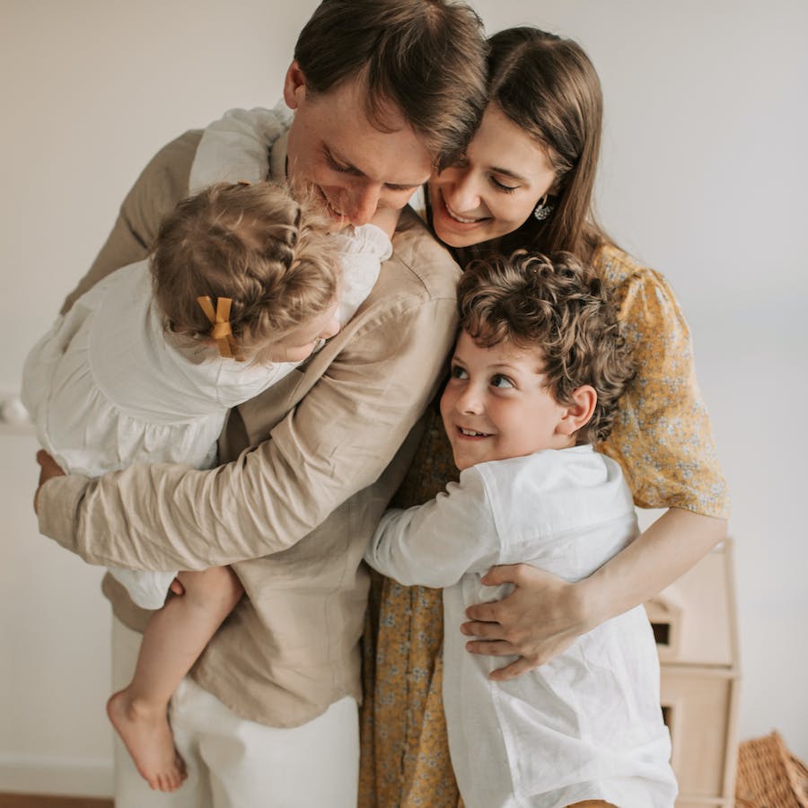 Photo of happy family of four hugging