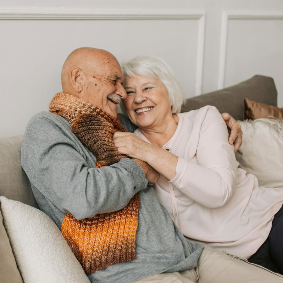 Man in gray sweater hugging woman next to him
