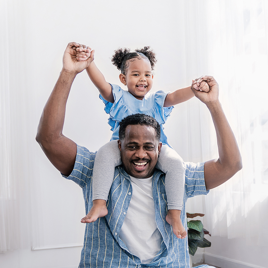 Happy black African American father daughter playing at home living room. Afro man carry piggyback little toddler girl. Cheerful family bonding together fatherâs day concept banner with copy space