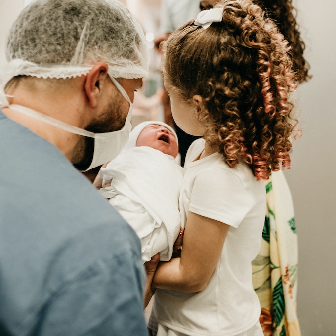 Provider helping sister hold new sibling