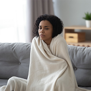 woman wrapped in blanket at home