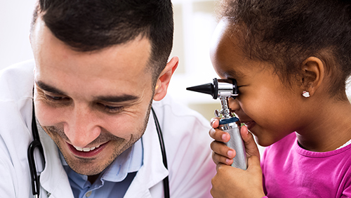 young child with otoscope and pediatric doctor