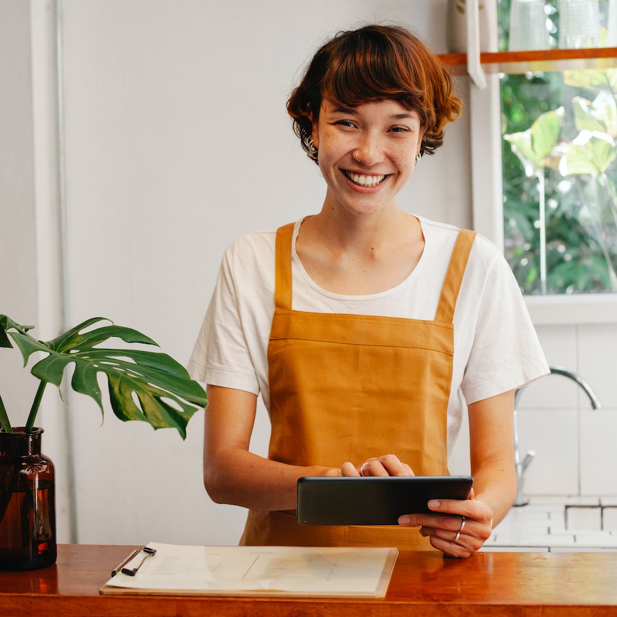 Cheerful employee with tablet at counter 