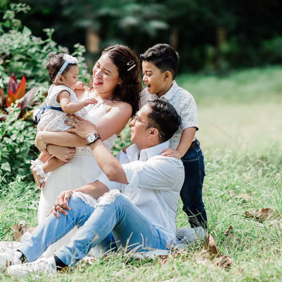 Family of 4 sitting in the grass