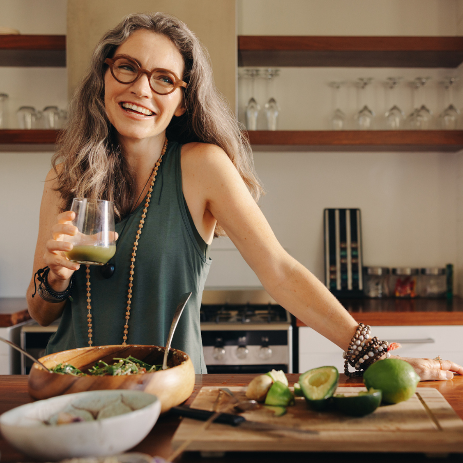 Healthy senior woman smiling while holding green juice