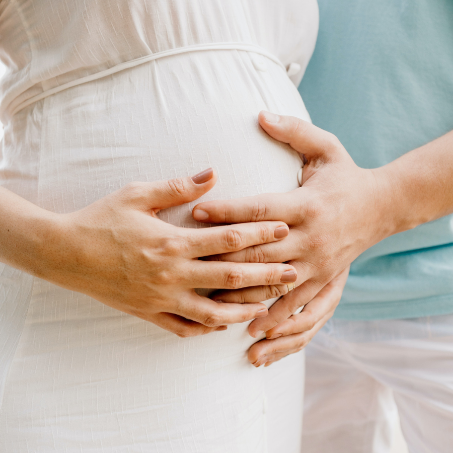 Pregnant couple holding womans belly