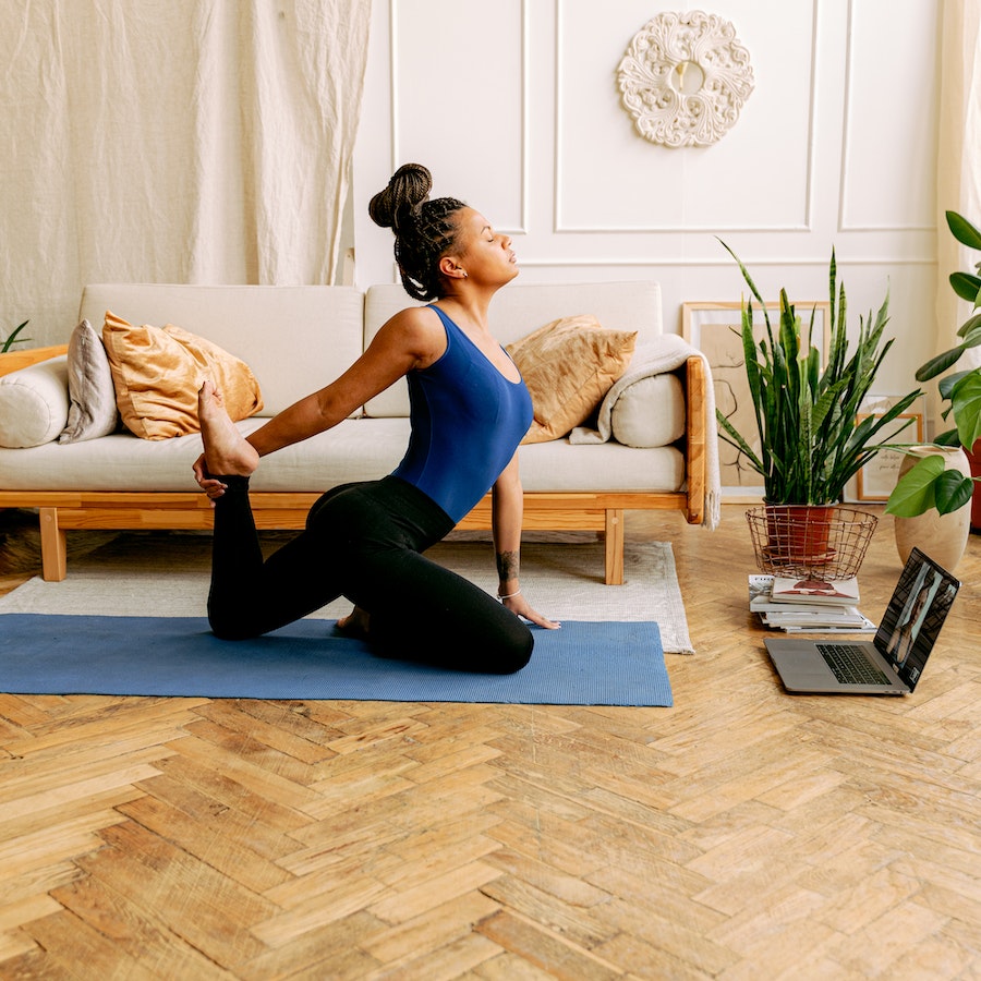 Woman in blue tank top doing a yoga pose