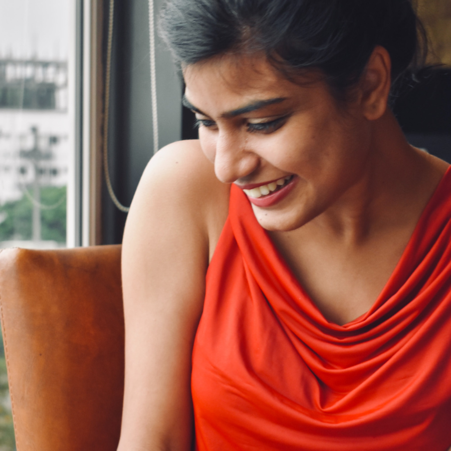 woman in red tank top sitting on brown sofa