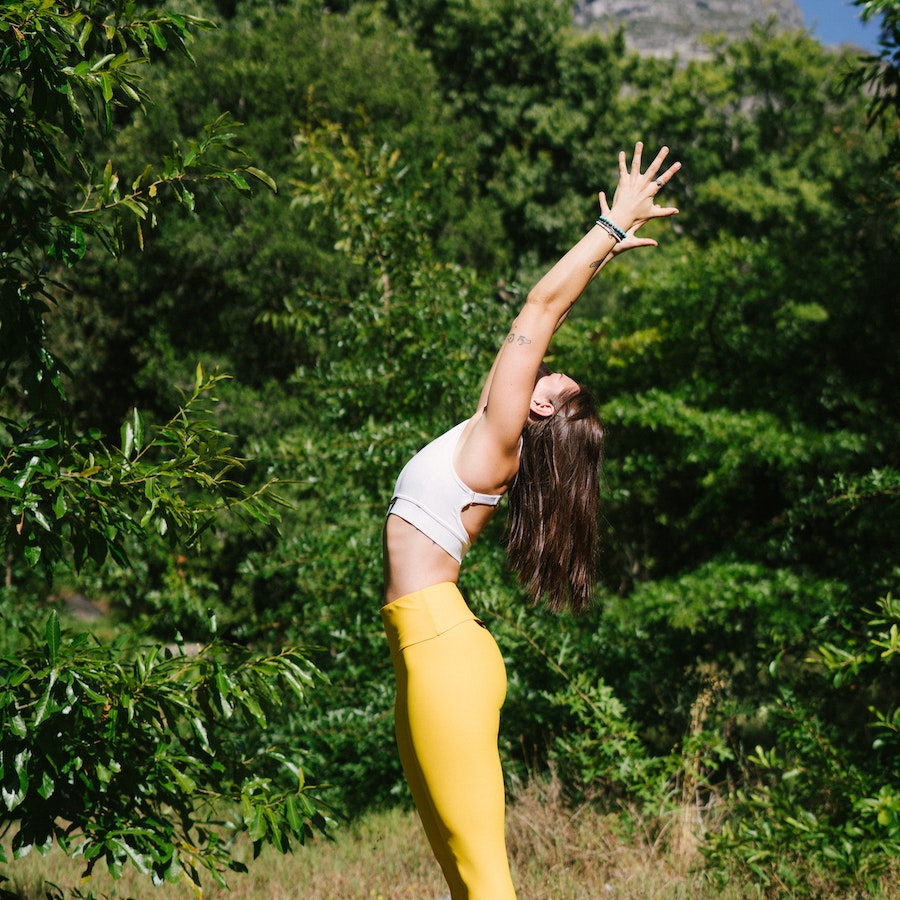 Woman in yellow yoga pants stretching