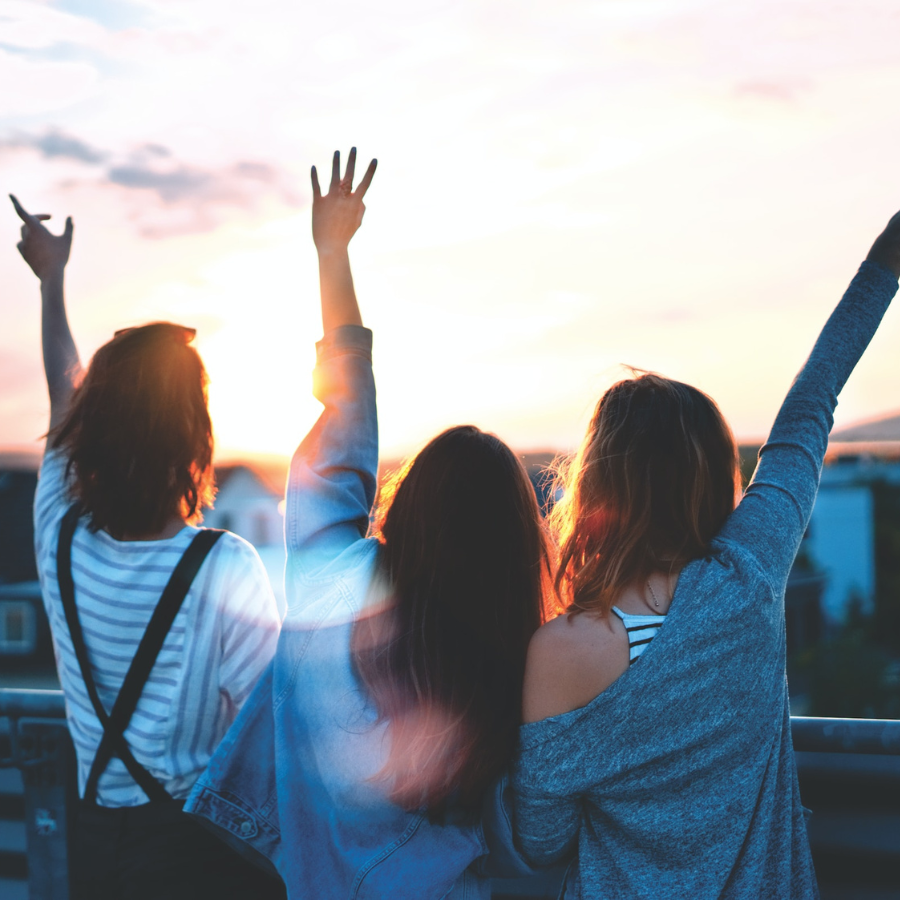 Women standing on balcony watching the sunset