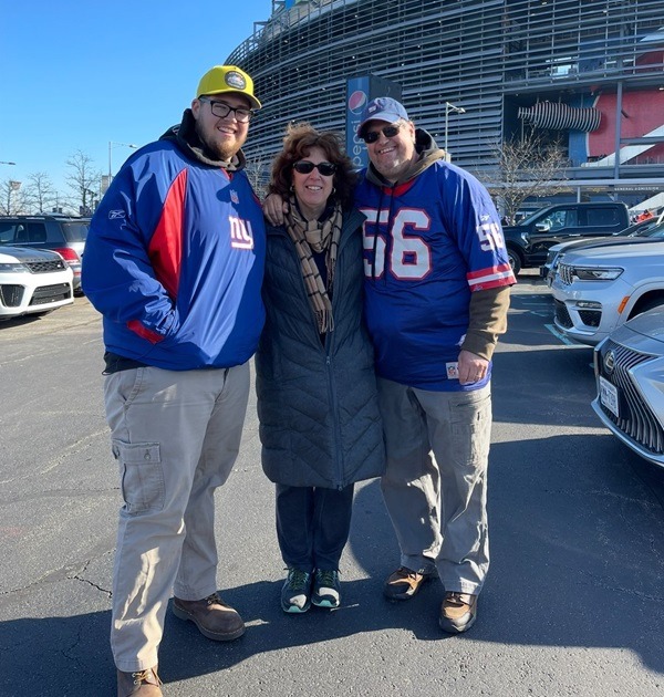 Zachary Sanford, a lung cancer patient at Vassar Brothers Medical Center, with his mom and dad outside of a football stadium.