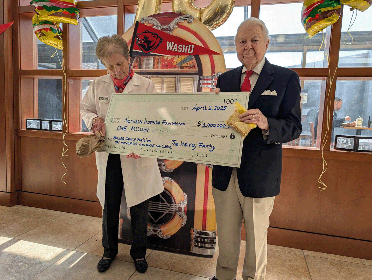 Carol and George Bauer hold $1M check donated by the Helvey Family. 