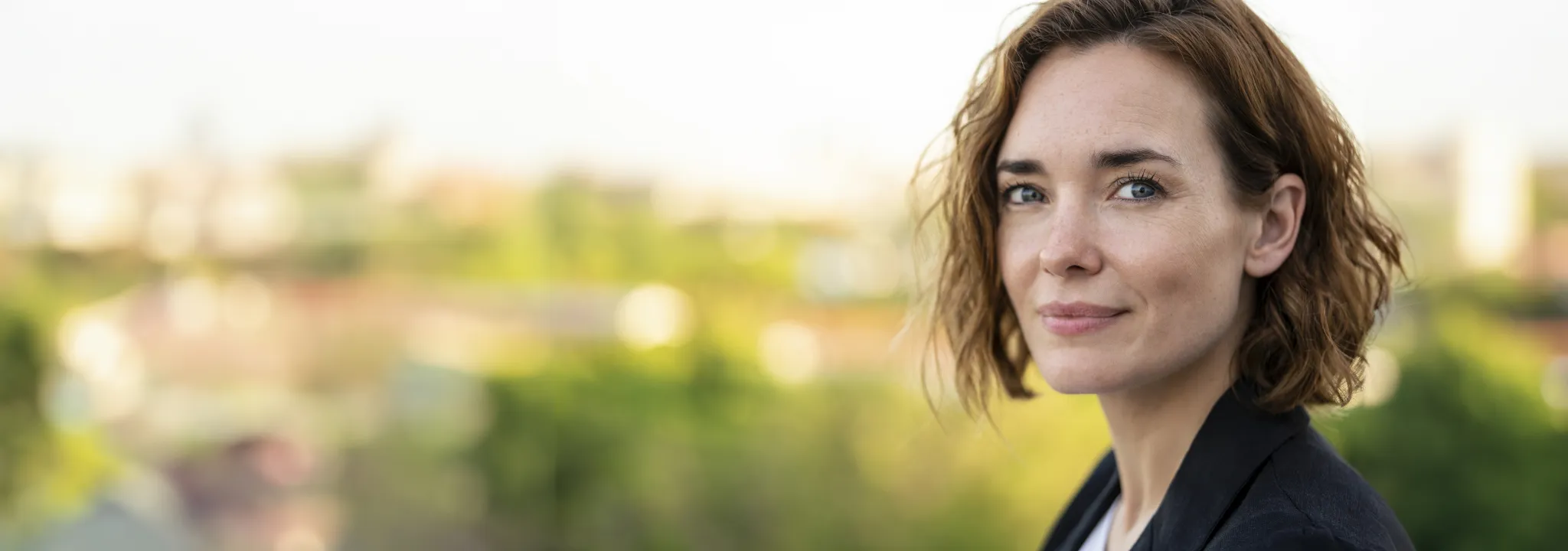 Hero - Portrait of smiling businesswoman standing outdoors