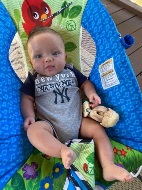 Dylans story - chunky baby sits in chair with Yankees outfit on
