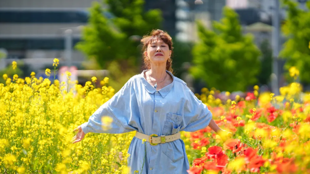 Senior woman at the flower field breathing easy because her migraines are controlled during allergy season.