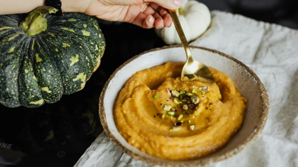 Hand Holding Spoon in Bowl with Food