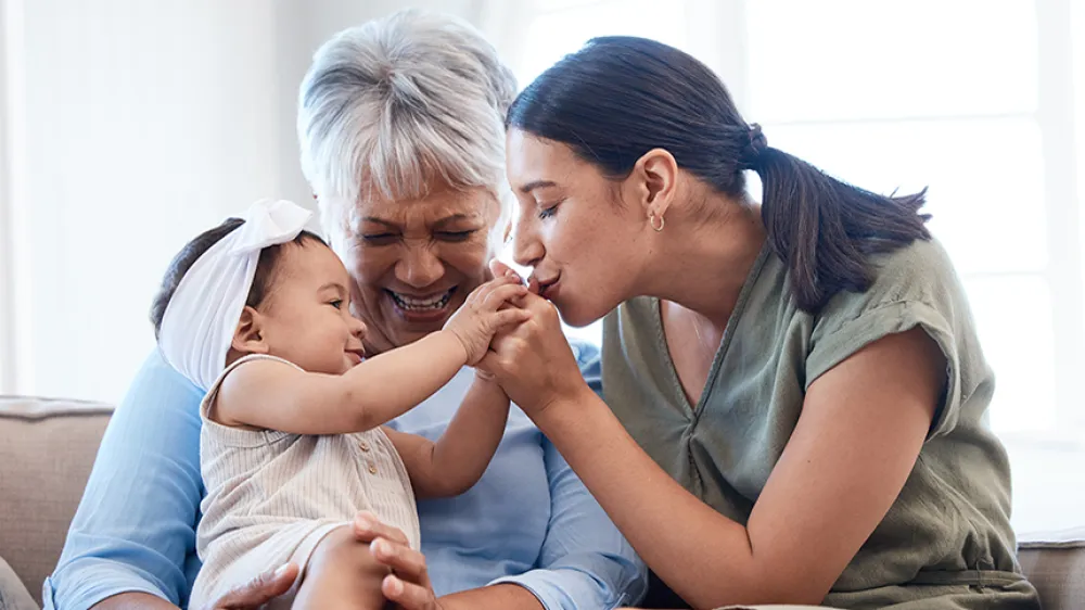 A grandmother and mother adore a young baby