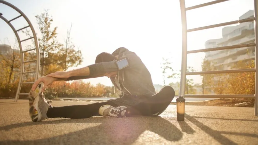 Flexible man stretching on ground