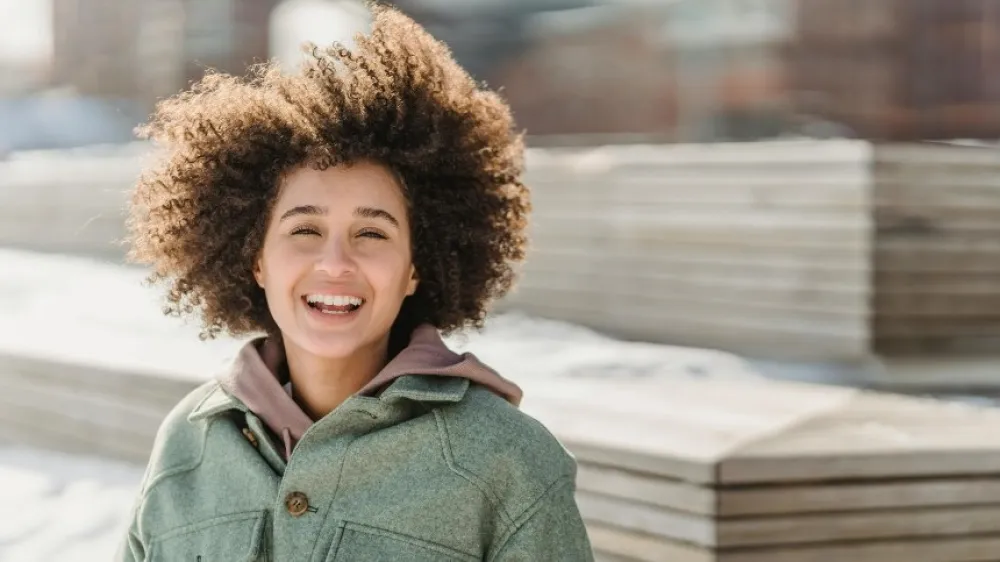 Hero - Smiling mixedracial woman outside with a snowy urban backdrop